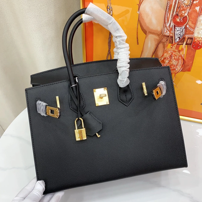 Sleek Solid Black Fine Grain Sharp Seam Structured Trapezoid Tote With Warm Golden Twist Lock Hardware And Detachable Matching Shoulder Strap