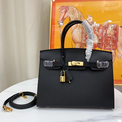 Sleek Solid Black Fine Grain Sharp Seam Structured Trapezoid Tote With Warm Golden Twist Lock Hardware And Detachable Matching Shoulder Strap