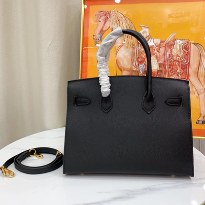 Sleek Solid Black Fine Grain Sharp Seam Structured Trapezoid Tote With Warm Golden Twist Lock Hardware And Detachable Matching Shoulder Strap